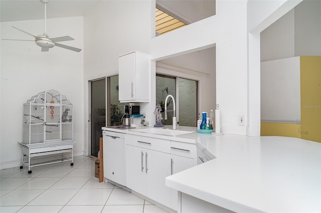 7833 Ontario Street Cir, Sarasota, FL 34243 - kitchen with white dishwasher, ceiling fan, white cabinetry, light countertops, and a towering ceiling