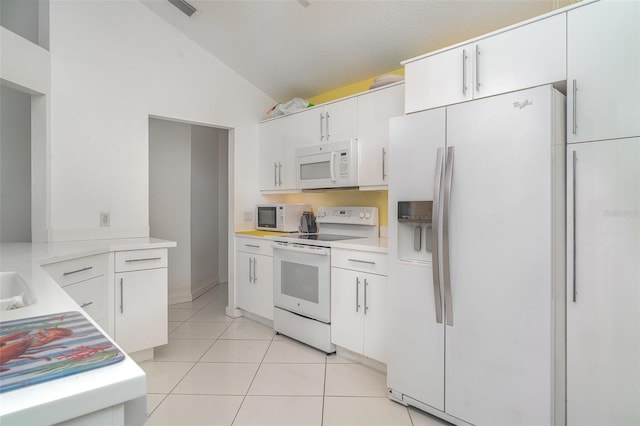 7833 Ontario Street Cir, Sarasota, FL 34243 - kitchen with white appliances, lofted ceiling, light countertops, light tile patterned floors, and white cabinetry