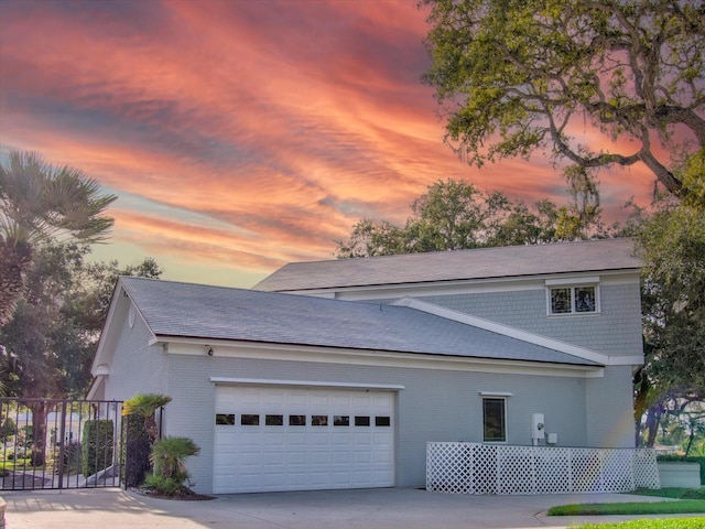 504 Riverside Dr Unit 504, Tarpon Springs, FL 34689 - view of home's exterior with brick siding, an attached garage, concrete driveway, and roof with shingles