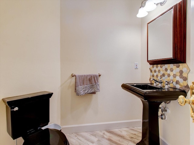 504 Riverside Dr Unit 504, Tarpon Springs, FL 34689 - bathroom with wood finished floors, decorative backsplash, and baseboards