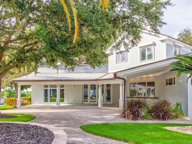 504 Riverside Dr Unit 504, Tarpon Springs, FL 34689 - rear view of property featuring covered porch and brick siding