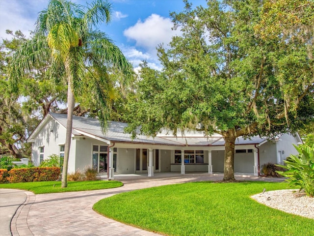 504 Riverside Dr Unit 504, Tarpon Springs, FL 34689 - rear view of property with a yard, decorative driveway, stucco siding, and a porch