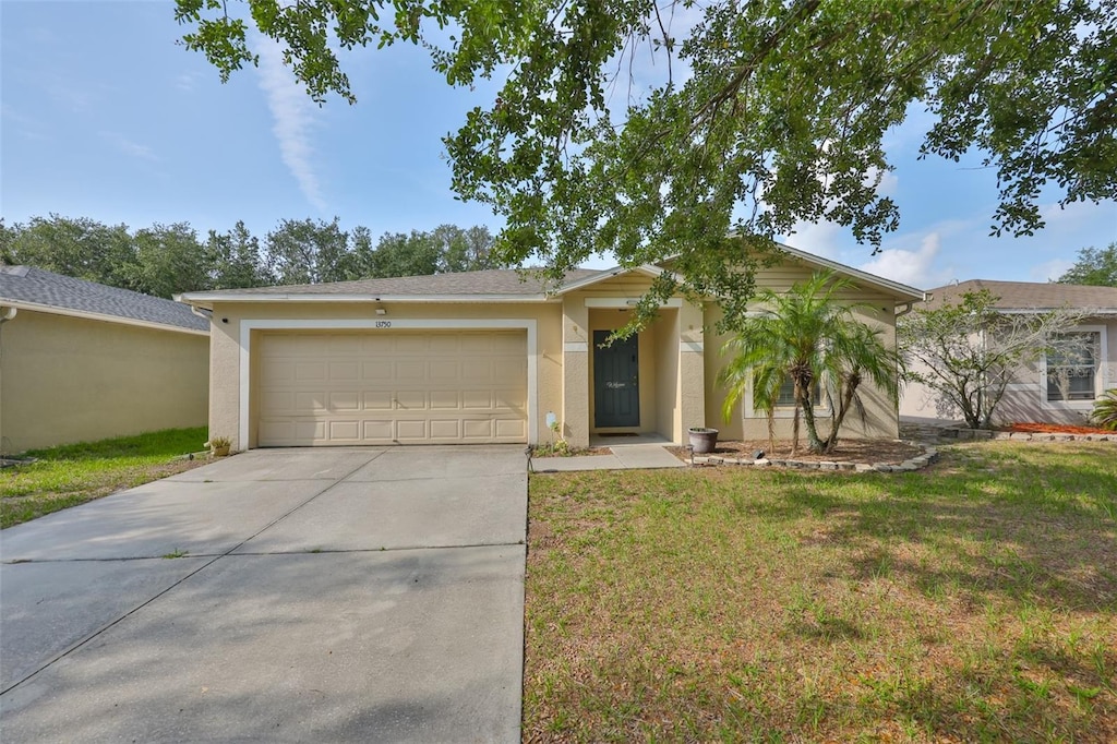 13750 Fareham Rd, Odessa, FL 33556 - ranch-style home featuring an attached garage, driveway, stucco siding, and a front lawn