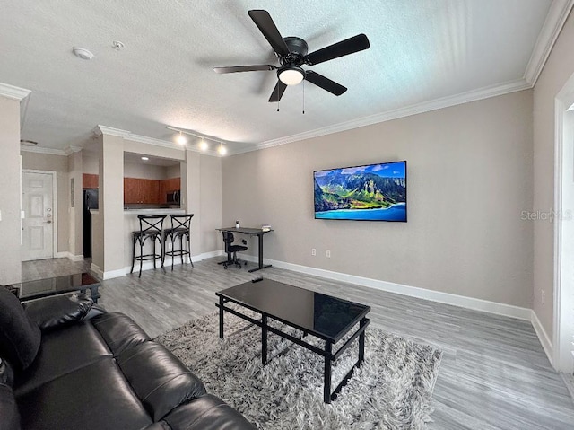 202 E S St Unit 5050, Orlando, FL 32801 - living room featuring wood finished floors, a textured ceiling, ornamental molding, ceiling fan, and baseboards