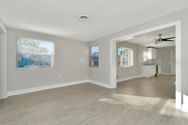 243 45th St N, Saint Petersburg, FL 33713 - unfurnished living room with wood finished floors, baseboards, and ceiling fan