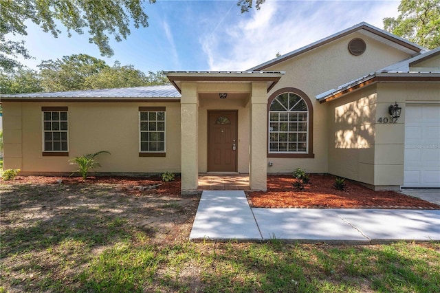 4032 Albany Rd, Labelle, FL 33935 - view of front of house with metal roof, stucco siding, and a garage