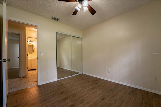 4032 Albany Rd, Labelle, FL 33935 - unfurnished bedroom with wood finished floors, a closet, baseboards, a textured ceiling, and a ceiling fan