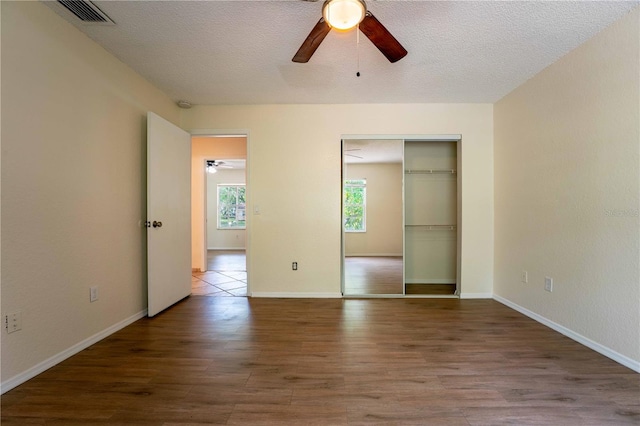 4032 Albany Rd, Labelle, FL 33935 - unfurnished bedroom featuring wood finished floors, a closet, a ceiling fan, baseboards, and a textured ceiling