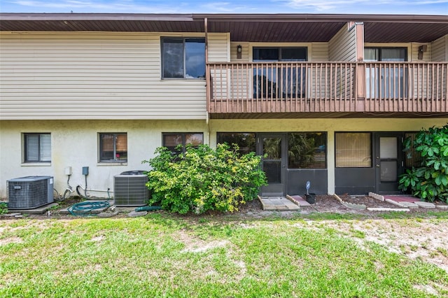 940 Fenton Ln Unit 7, Lakeland, FL 33809 - back of house with central AC unit, a balcony, stucco siding, and a lawn