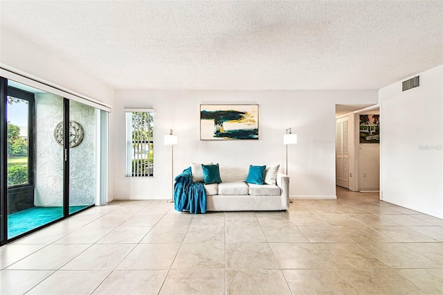 1109 Pine Ridge Cir W Unit C1, Tarpon Springs, FL 34688 - living area featuring a textured ceiling and light tile patterned flooring