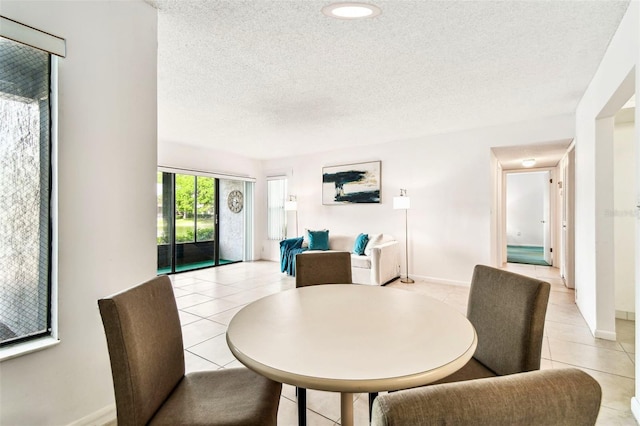 1109 Pine Ridge Cir W Unit C1, Tarpon Springs, FL 34688 - dining room featuring light tile patterned floors, a textured ceiling, and baseboards