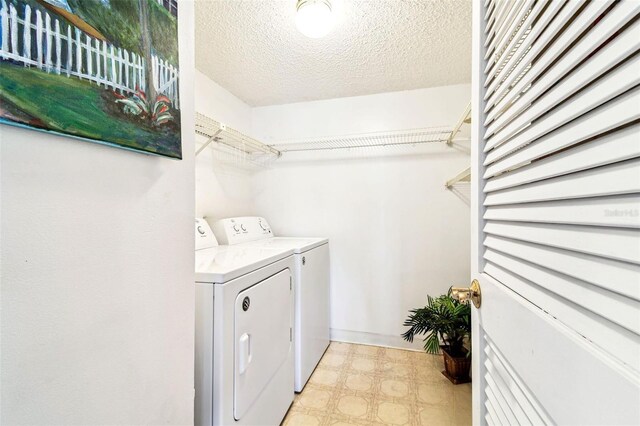 1109 Pine Ridge Cir W Unit C1, Tarpon Springs, FL 34688 - laundry area featuring washing machine and dryer, light floors, and a textured ceiling