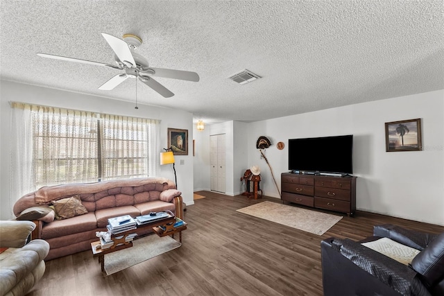 1633 Bentwood Dr, Sun City Center, FL 33573 - living room featuring ceiling fan, dark wood-type flooring, a textured ceiling, and baseboards