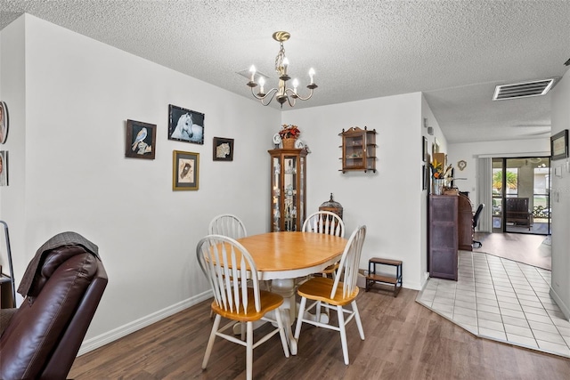 1633 Bentwood Dr, Sun City Center, FL 33573 - dining room featuring a chandelier, a textured ceiling, wood finished floors, and baseboards