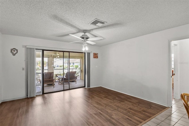 1633 Bentwood Dr, Sun City Center, FL 33573 - spare room with ceiling fan, wood finished floors, a textured ceiling, and baseboards