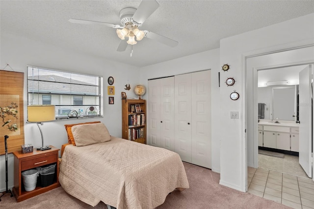 1633 Bentwood Dr, Sun City Center, FL 33573 - bedroom with a closet, a ceiling fan, a textured ceiling, light tile patterned flooring, and a sink