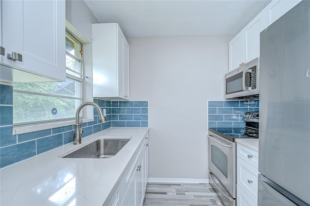 6004 S 82nd St, Tampa, FL 33619 - kitchen with stainless steel appliances, a sink, backsplash, and white cabinetry