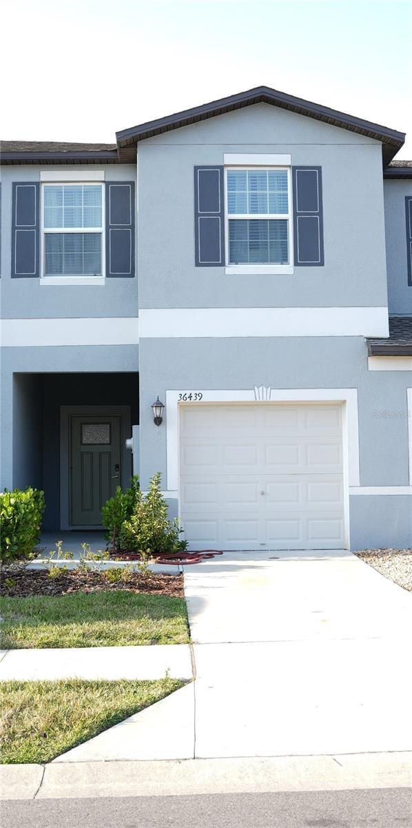 36439 Garden Wall Way, Zephyrhills, FL 33541 - traditional-style house featuring stucco siding, an attached garage, and driveway