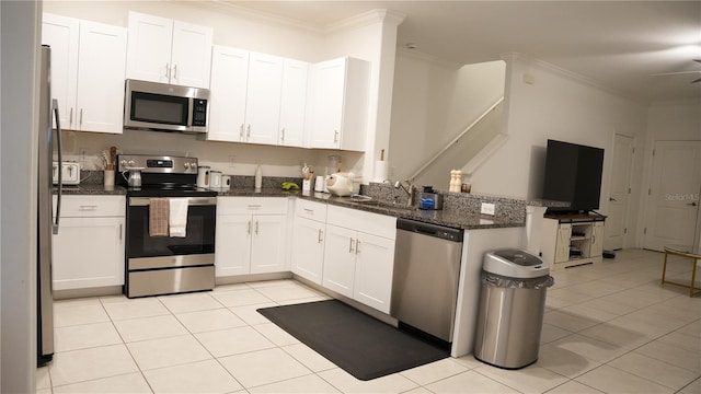 36439 Garden Wall Way, Zephyrhills, FL 33541 - kitchen featuring appliances with stainless steel finishes, ornamental molding, a peninsula, light tile patterned flooring, and white cabinetry