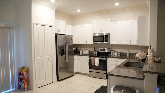 36439 Garden Wall Way, Zephyrhills, FL 33541 - kitchen featuring stainless steel appliances, white cabinetry, dark stone countertops, light tile patterned floors, and a peninsula