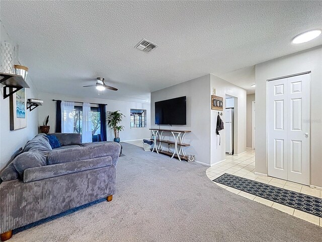 2031 Dover Ct, Oldsmar, FL 34677 - living room with light carpet, ceiling fan, light tile patterned floors, a textured ceiling, and baseboards