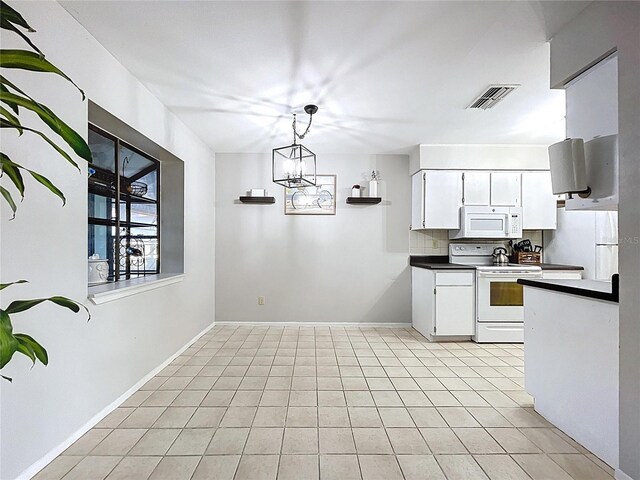 2031 Dover Ct, Oldsmar, FL 34677 - kitchen with white appliances, dark countertops, white cabinets, and light tile patterned flooring