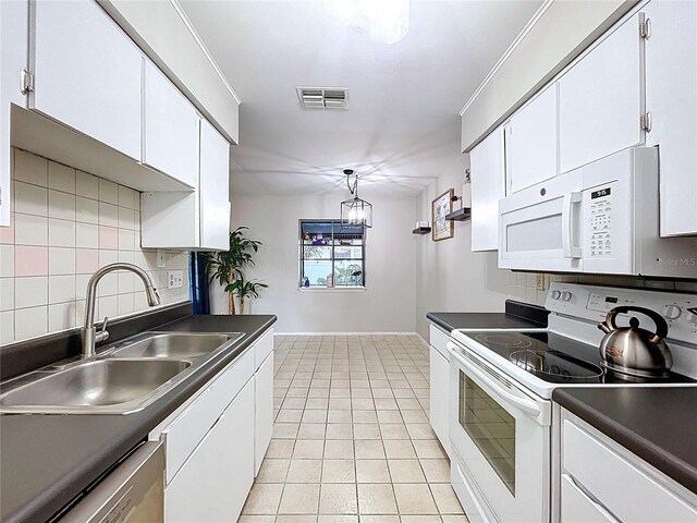2031 Dover Ct, Oldsmar, FL 34677 - kitchen featuring white appliances, a sink, dark countertops, and white cabinetry