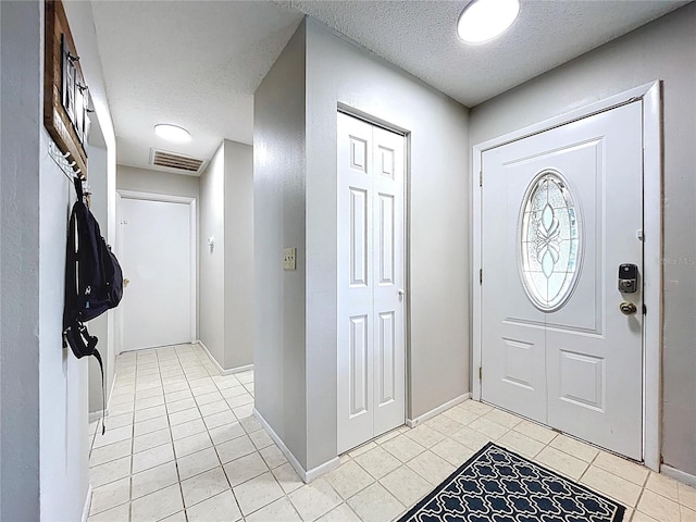 2031 Dover Ct, Oldsmar, FL 34677 - entryway featuring a textured ceiling, light tile patterned floors, and baseboards
