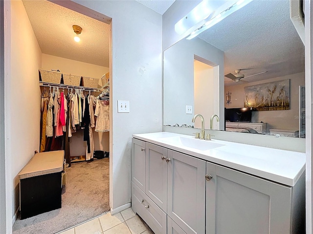 2031 Dover Ct, Oldsmar, FL 34677 - bathroom with a textured ceiling, vanity, tile patterned flooring, and a spacious closet