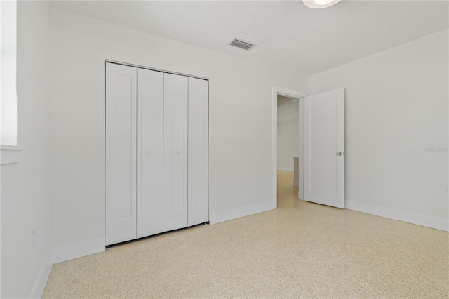 433 Pineapple St, Tarpon Springs, FL 34689 - unfurnished bedroom with baseboards, speckled floor, and a closet