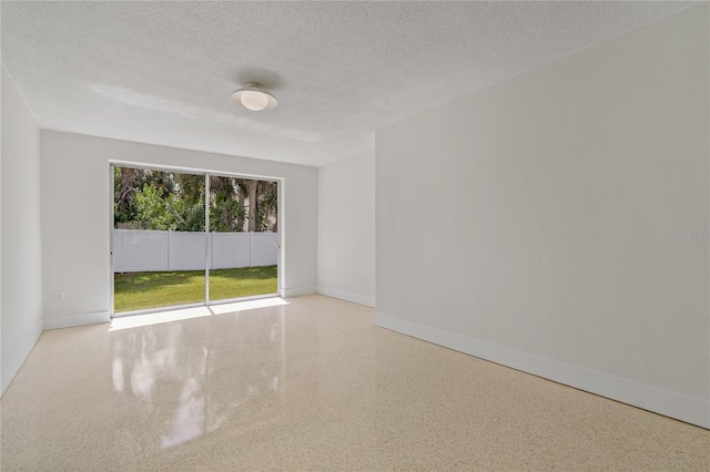 433 Pineapple St, Tarpon Springs, FL 34689 - spare room featuring speckled floor, a textured ceiling, and baseboards