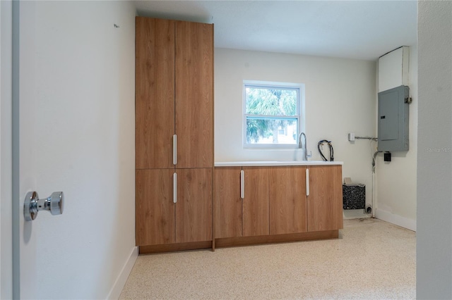 433 Pineapple St, Tarpon Springs, FL 34689 - kitchen featuring electric panel, brown cabinetry, baseboards, and light countertops