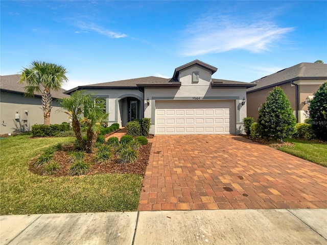 19664 Ship Wheel Way, Land O Lakes, FL 34638 - view of front of home featuring stucco siding, decorative driveway, a garage, and a front yard