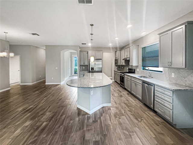 19664 Ship Wheel Way, Land O Lakes, FL 34638 - kitchen with appliances with stainless steel finishes, a sink, gray cabinets, arched walkways, and dark wood-type flooring