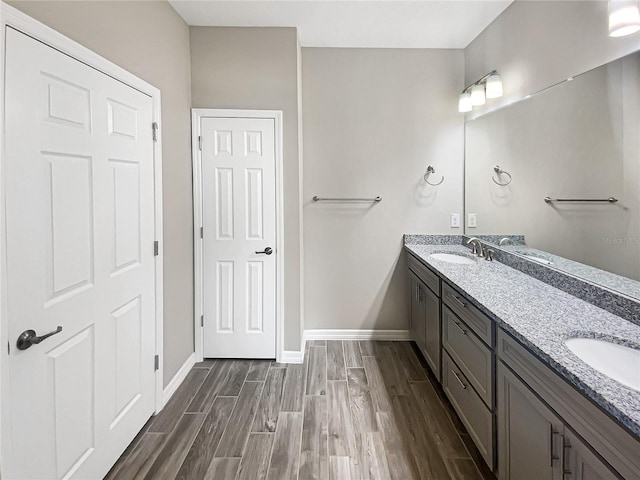 19664 Ship Wheel Way, Land O Lakes, FL 34638 - bathroom featuring double vanity, wood finished floors, and baseboards