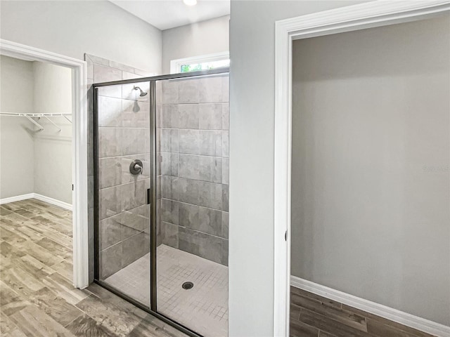 19664 Ship Wheel Way, Land O Lakes, FL 34638 - full bathroom with a stall shower, wood finished floors, baseboards, and a walk in closet