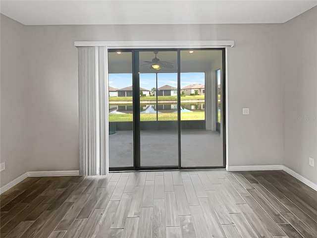 19664 Ship Wheel Way, Land O Lakes, FL 34638 - spare room featuring wood finish floors, a water view, baseboards, and a ceiling fan