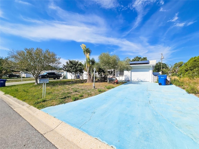 2066 High Ridge Dr, Clearwater, FL 33763 - view of property hidden behind natural elements featuring roof mounted solar panels, driveway, a front lawn, and a garage