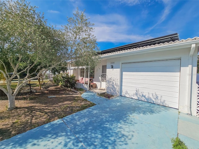 2066 High Ridge Dr, Clearwater, FL 33763 - view of front of home featuring concrete driveway, a garage, roof mounted solar panels, and brick siding