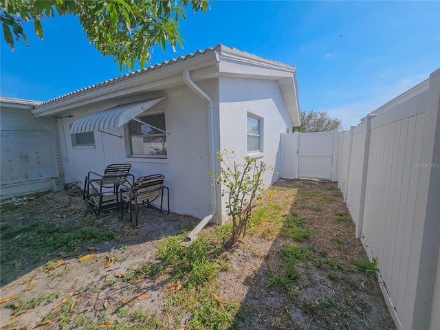 2066 High Ridge Dr, Clearwater, FL 33763 - view of property exterior featuring stucco siding, a fenced backyard, a gate, and a tile roof