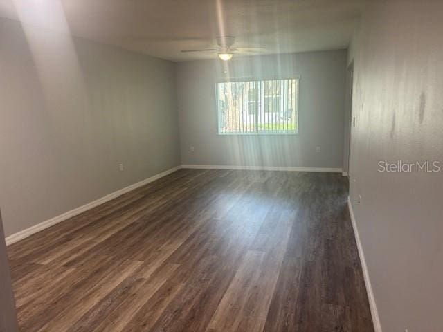 6520 Thicket Trl, New Port Richey, FL 34653 - spare room featuring a ceiling fan, dark wood-style floors, and baseboards