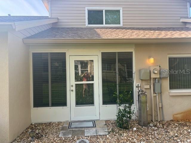 6520 Thicket Trl, New Port Richey, FL 34653 - property entrance featuring a shingled roof and stucco siding