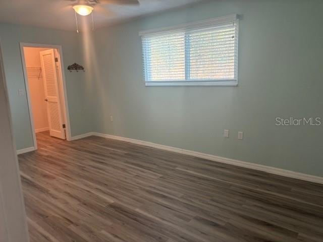 6520 Thicket Trl, New Port Richey, FL 34653 - empty room featuring baseboards, dark wood-style floors, and a ceiling fan