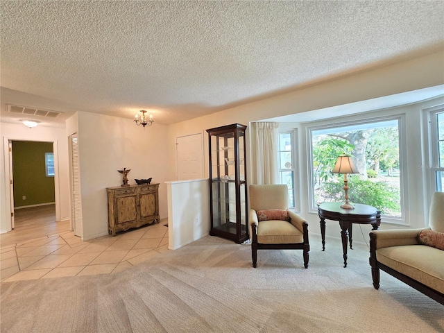 3509 Oak Lake Dr, Palm Harbor, FL 34684 - sitting room with light tile patterned flooring, a chandelier, light colored carpet, and a textured ceiling
