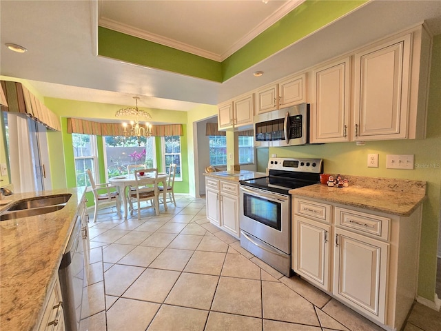 3509 Oak Lake Dr, Palm Harbor, FL 34684 - kitchen with appliances with stainless steel finishes, cream cabinetry, a chandelier, light tile patterned floors, and crown molding