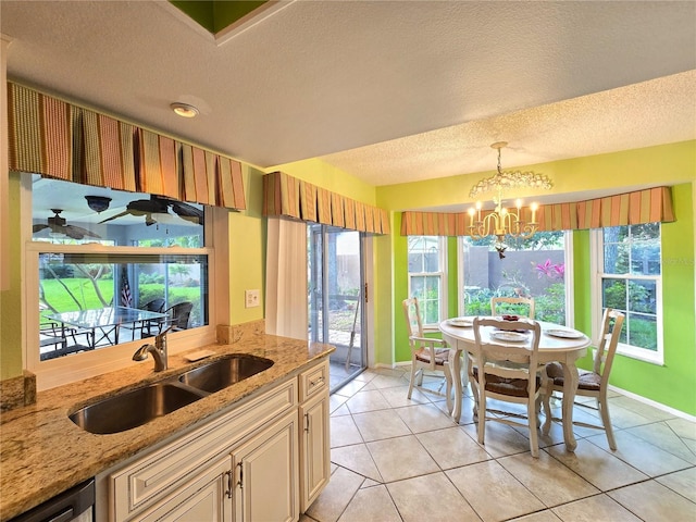 3509 Oak Lake Dr, Palm Harbor, FL 34684 - kitchen featuring a sink, a textured ceiling, baseboards, light stone counters, and pendant lighting