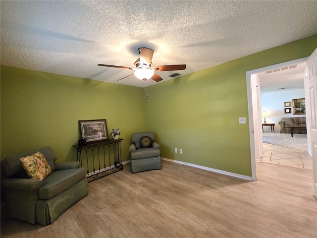 3509 Oak Lake Dr, Palm Harbor, FL 34684 - sitting room featuring a ceiling fan, light wood-type flooring, a textured ceiling, and baseboards
