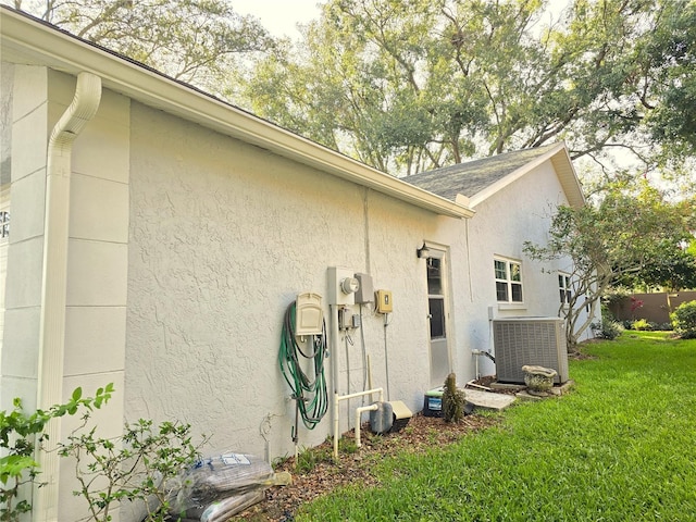 3509 Oak Lake Dr, Palm Harbor, FL 34684 - view of home's exterior featuring central AC, a yard, and stucco siding