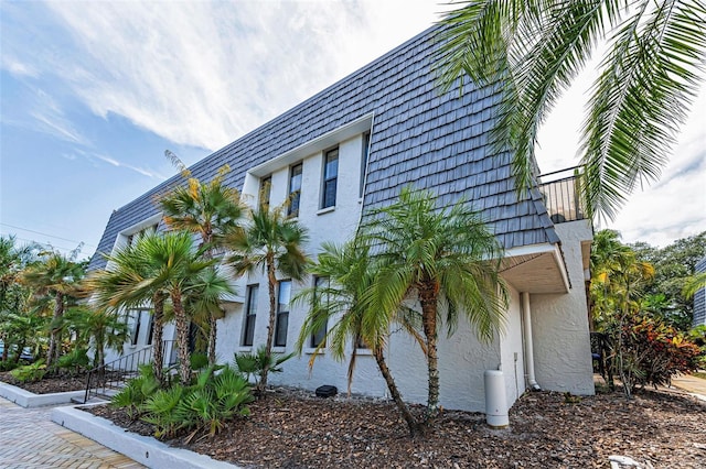 704 Lyndhurst St Unit 624, Dunedin, FL 34698 - view of side of property featuring mansard roof and stucco siding