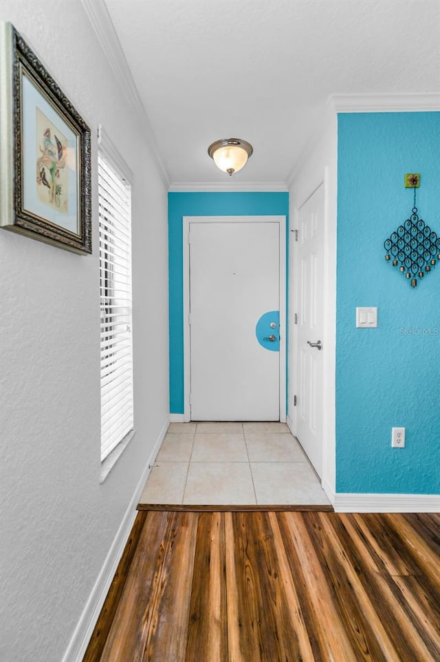 704 Lyndhurst St Unit 624, Dunedin, FL 34698 - doorway featuring baseboards, light wood-style flooring, crown molding, and a textured wall